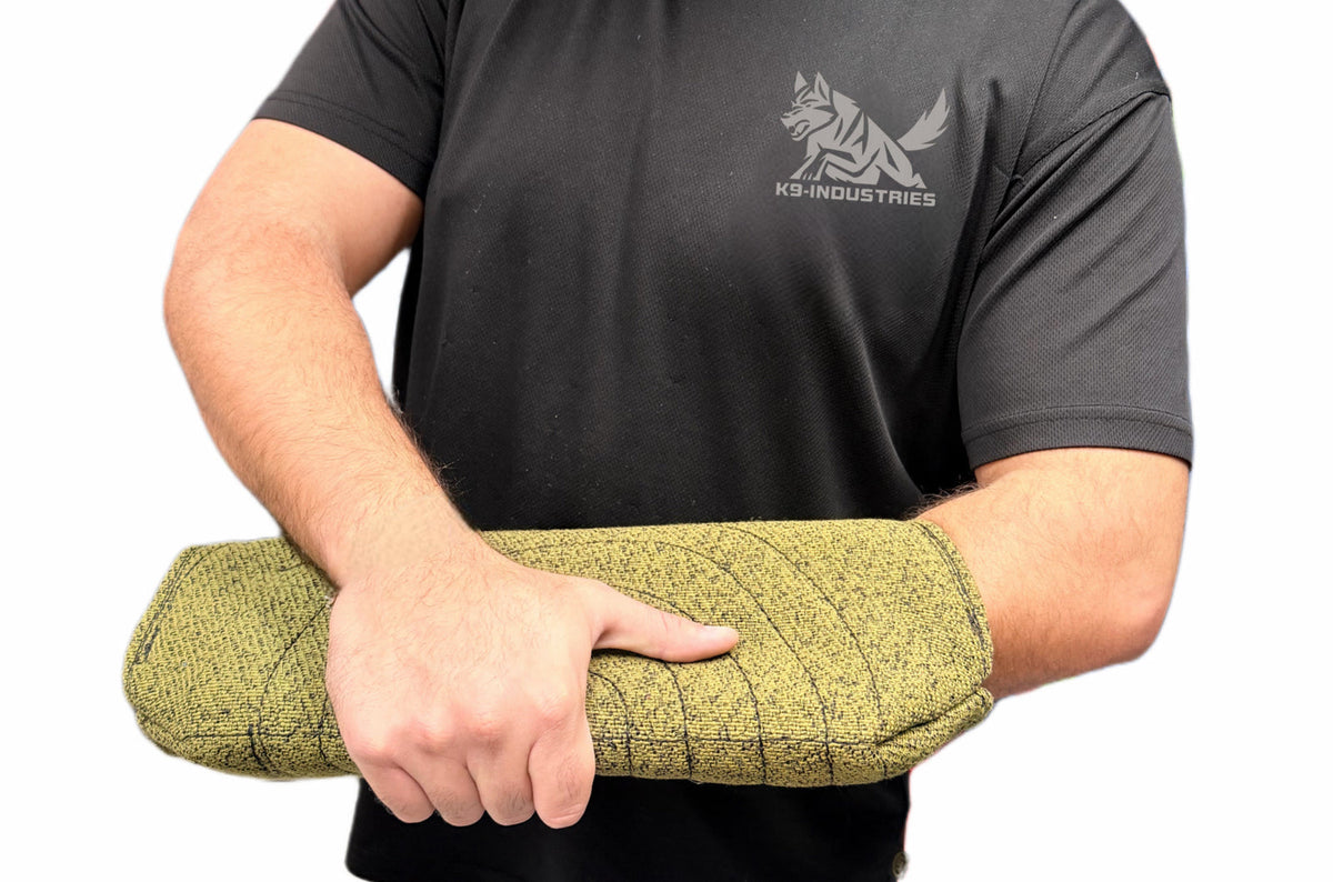 Trainer holding a jute bite sleeve across the forearm, the equipment used for young dog bite work